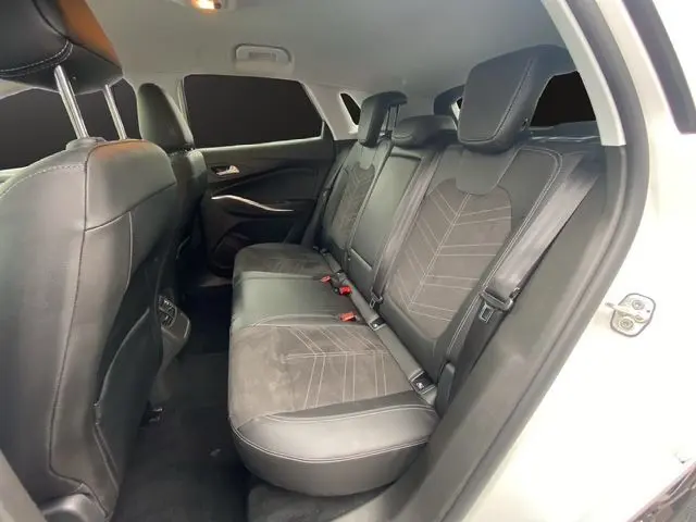 Vue intérieure arrière droite montrant la banquette en cuir et tissu noir du Opel Grandland blanc Arktis toit noir 2024.