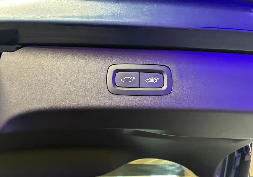 Boutons de commande d'ouverture et de verrouillage électrique du hayon sur un LYNK & CO 01 bleu hybride rechargeable.