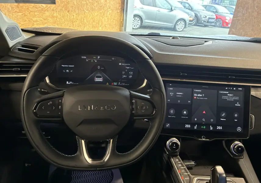 Vue intérieure centrée sur le volant LYNK & CO 01 avec tableau de bord digital et écran tactile moderne.