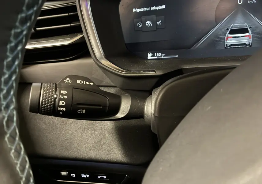 Gros plan sur la commande des feux et le tableau de bord digital affichant le régulateur adaptatif du Lynk & Co 01 bleu 2023.