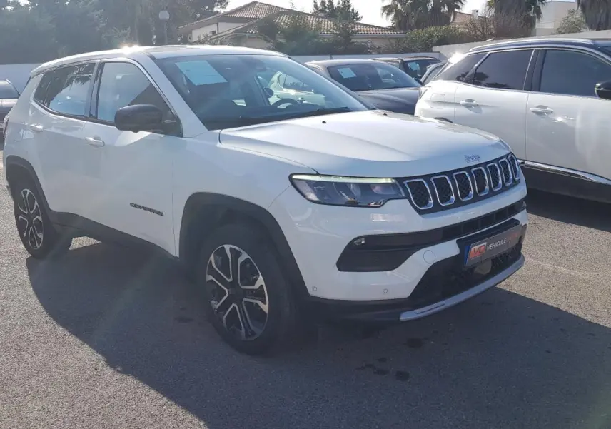 Jeep Compass blanc en vue 3/4 avant droit, avec jantes alliage 18 pouces et calandre distinctive à sept fentes.