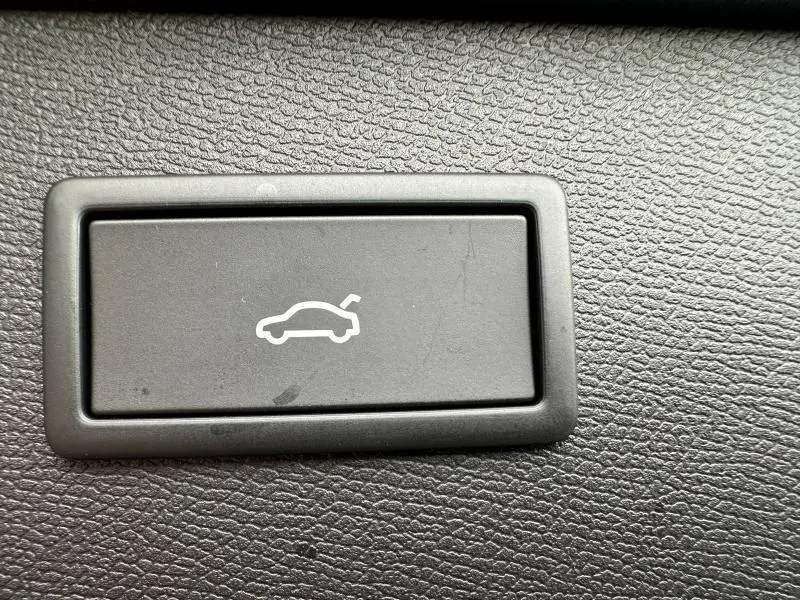 Bouton noir de déverrouillage du coffre sur tableau de bord texturé d'une CUPRA Formentor gris Graphène.