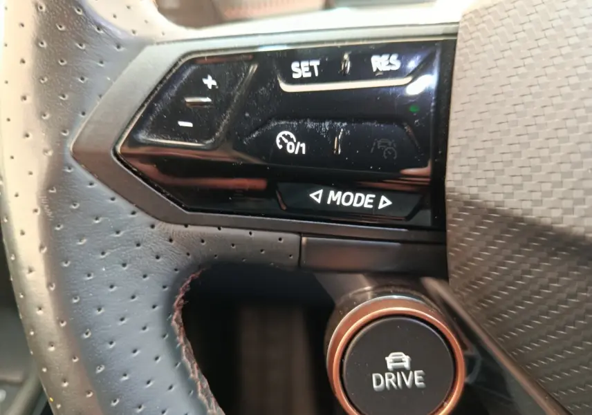 Gros plan sur le volant cuir perforé et les commandes multifonctions noires du CUPRA Born gris foncé 2023.