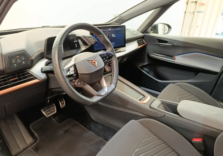 Vue intérieure côté conducteur du CUPRA BORN 230ch gris foncé, volant cuir multifonctions et écran tactile central.