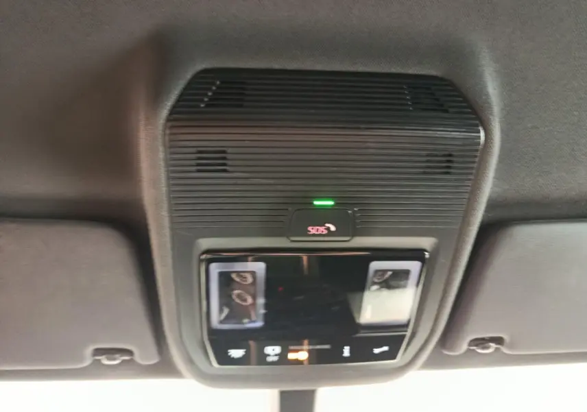 Vue en gros plan du plafonnier intérieur noir avec bouton SOS illuminé en vert dans une CUPRA Born gris foncé.