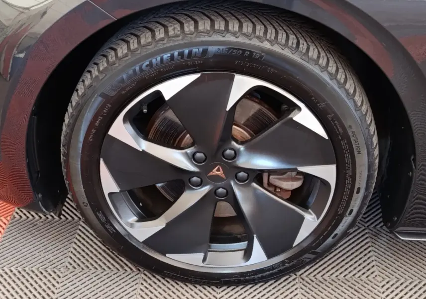 Gros plan sur la roue avant droite du CUPRA BORN gris foncé avec jante alliage bicolore et logo CUPRA central.