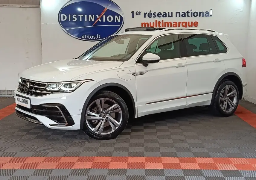 Volkswagen Tiguan blanc 2023 hybride rechargeable en 3/4 avant droit avec jantes alliage et toit ouvrant.
