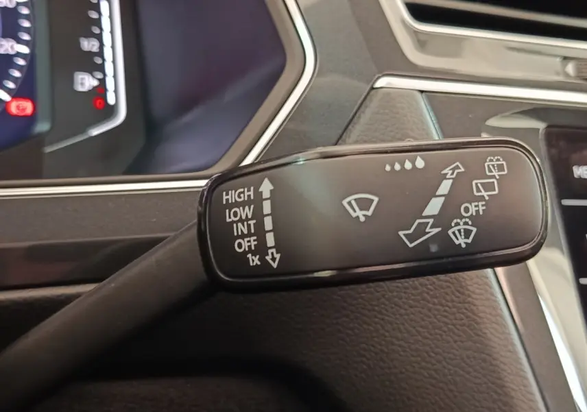 Gros plan sur la commande des essuie-glaces dans l'habitacle du Volkswagen Tiguan blanc 2023.