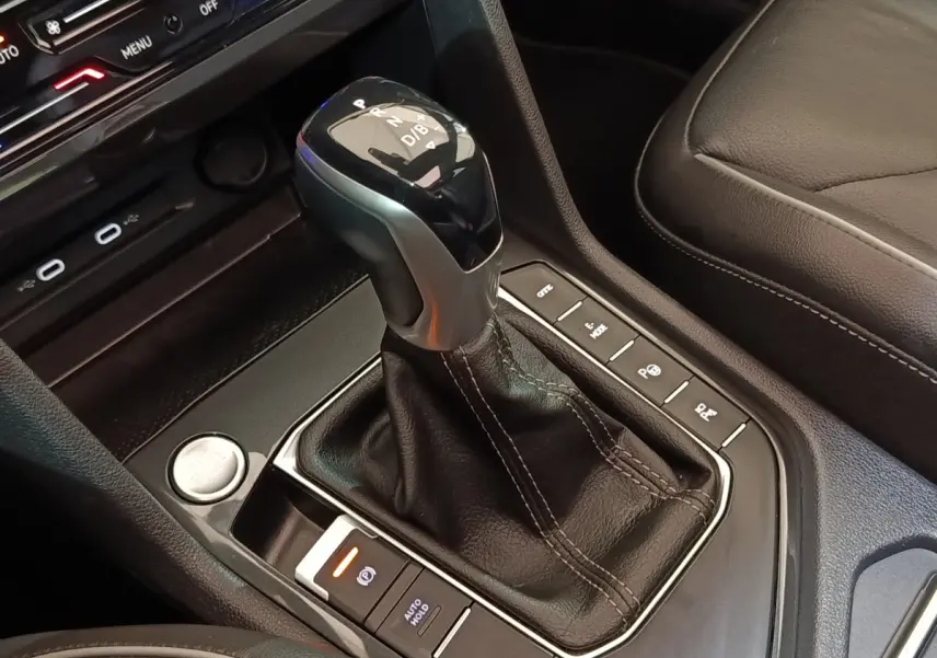 Le levier de vitesses automatique noir et argent du Volkswagen Tiguan 1.4 eHybrid, avec boutons de contrôle autour.