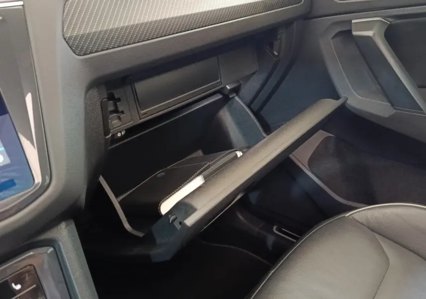 Intérieur du Volkswagen Tiguan 2023, vue sur la boîte à gants ouverte côté passager avec siège en cuir gris.