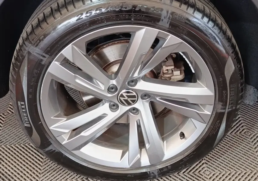 Gros plan sur la jante alliage argentée avec logo Volkswagen du Volkswagen Tiguan blanc 1.4 EHYBRID 2023.