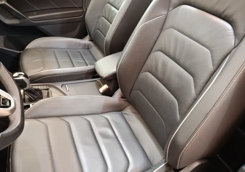 Gros plan sur les sièges avant en cuir noir du Volkswagen Tiguan 1.4 eHybrid 2023, vue côté conducteur.