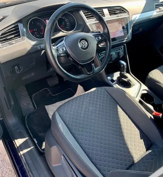 Intérieur du Volkswagen Tiguan 2018, vue côté conducteur montrant volant, tableau de bord et siège tissu gris.