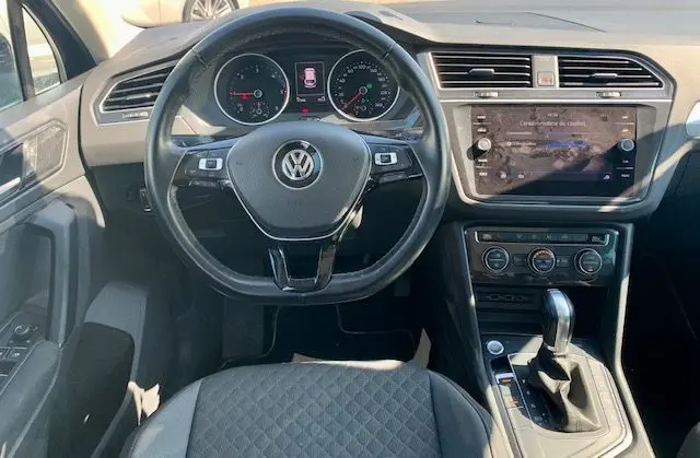 Vue intérieure du tableau de bord et volant d'un Volkswagen Tiguan 2018, finition Confortline Business, avec boîte automatique.