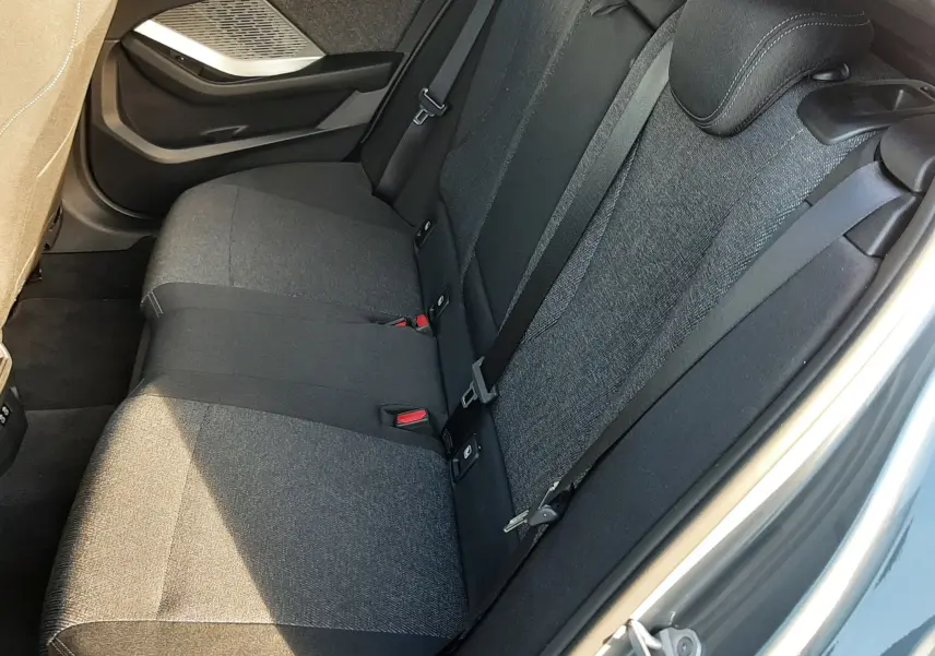 Vue intérieure côté arrière droit sur la banquette tissu noir et gris d'une BMW Série 1 F70 gris Skyscraper.