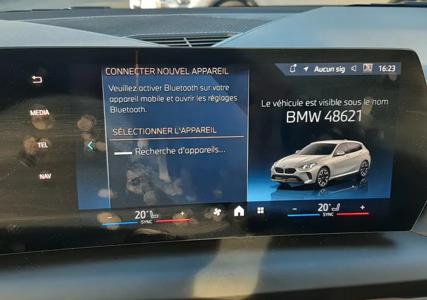 Écran central BMW montrant une illustration grise de la Série 1 F70 120D M Sport en vue 3/4 avant droite.