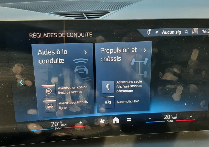 Écran tactile du tableau de bord BMW Série 1 120D 2025 montrant les réglages d'aides à la conduite et châssis.