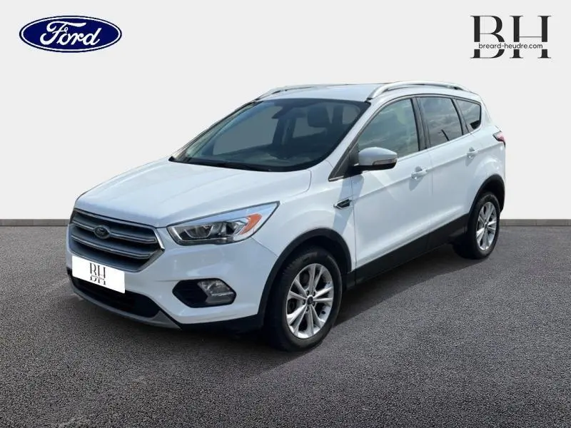 Ford Kuga blanc glacier vu en 3/4 avant droit avec barres de toit aluminium et jantes alliage.
