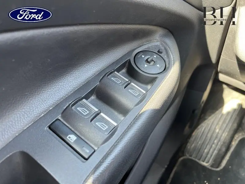 Gros plan sur les commandes des vitres électriques côté conducteur du Ford Kuga blanc glacier 2017.