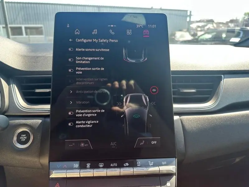 Vue intérieure centrée sur l'écran tactile du tableau de bord du Renault Captur 2025, affichant les aides à la conduite.