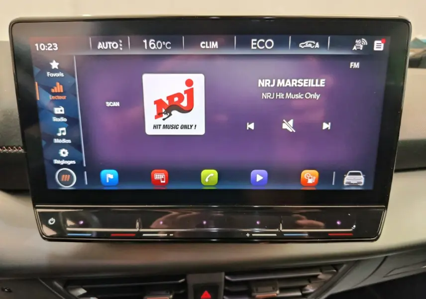 Écran tactile central affichant la radio NRJ dans l'habitacle d'une CUPRA BORN gris foncé, vue de face.