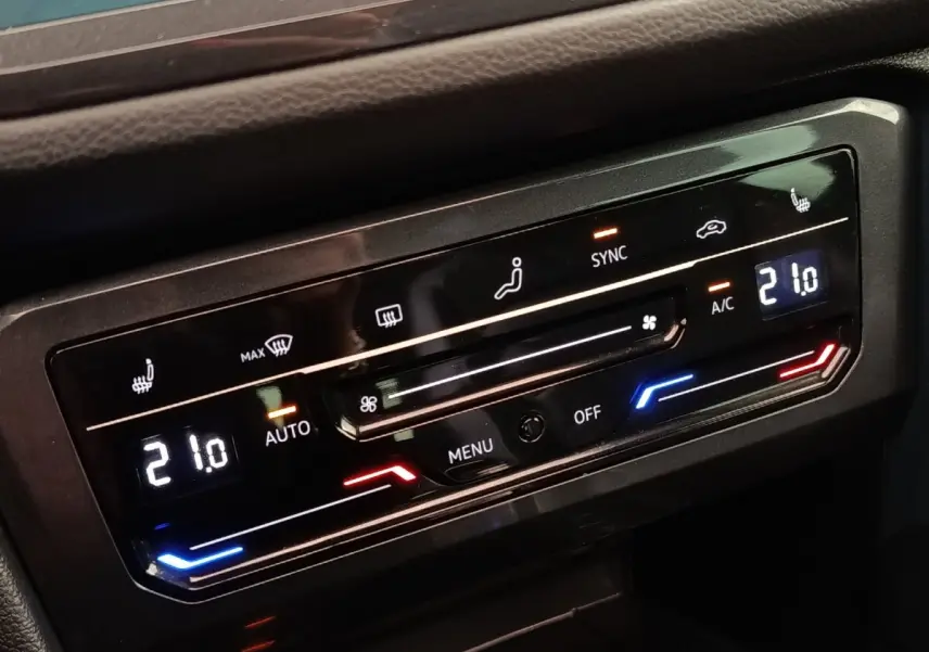 Détail du panneau de commande de la climatisation automatique 3 zones du Volkswagen Tiguan noir, affichage digital à 21°C.