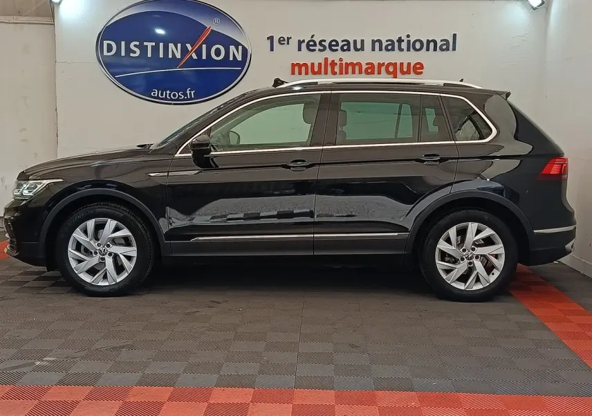 Vue de profil côté gauche d'un Volkswagen Tiguan noir 2.0 TDI 150 DSG7 Elegance dans un showroom.