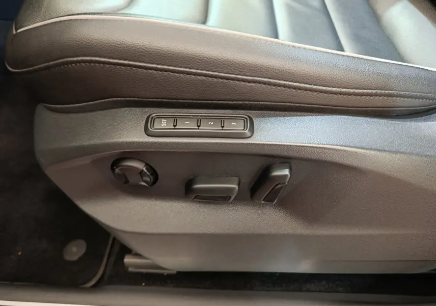 Détail côté gauche du siège conducteur noir en cuir avec commandes électriques et mémoire sur Volkswagen Tiguan 2021.