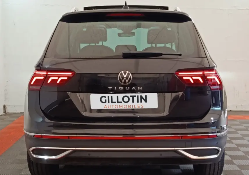 Vue arrière d’un Volkswagen Tiguan noir 2021 avec feux LED allumés et logo VW bien visible.