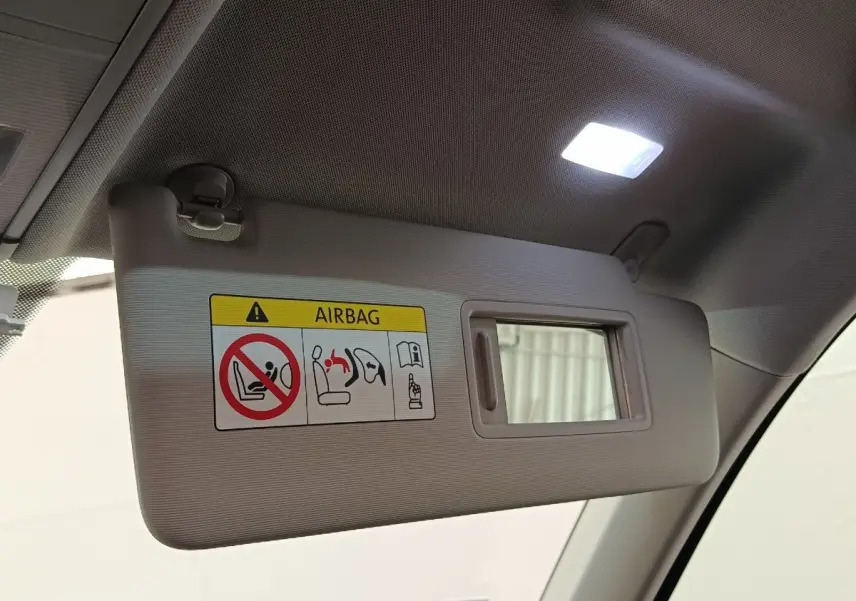 Pare-soleil côté conducteur beige avec miroir intégré et avertissement airbag, intérieur Volkswagen Tiguan noir 2021.