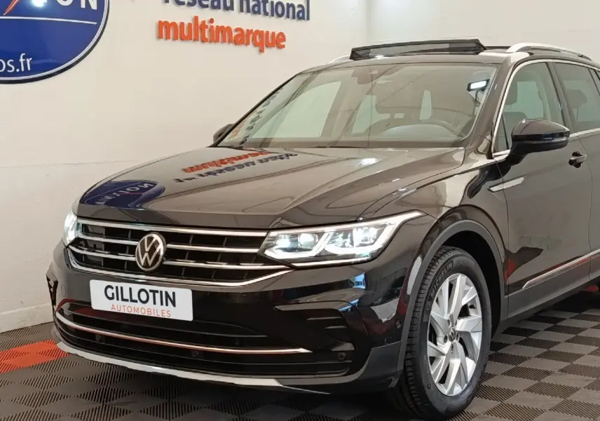 Volkswagen Tiguan noir 2021 en 3/4 avant droit, avec phares LED allumés et jantes alliage visibles.
