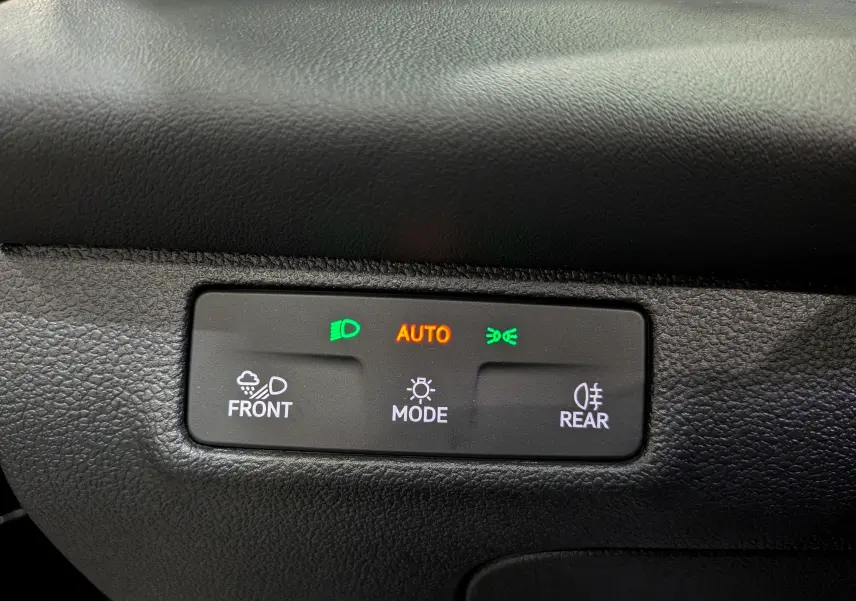 Panneau de commande des feux avec réglages automatiques et options frontales et arrière, intérieur noir du Volkswagen T-Roc.