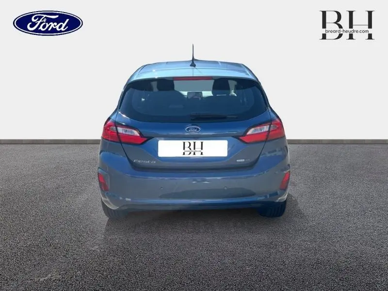 Vue arrière d'une Ford Fiesta 2022 bleu azur métallisé avec feux LED et becquet arrière distinctif.