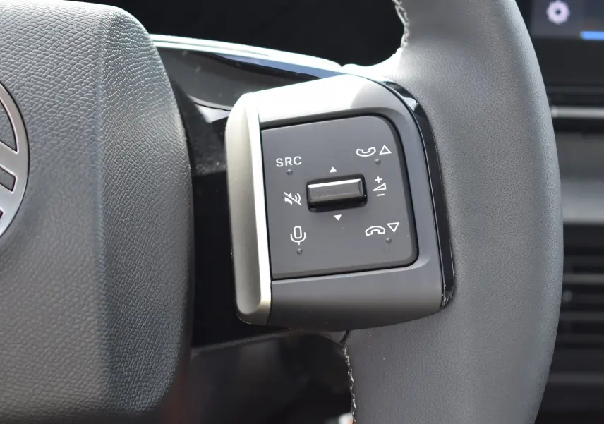 Gros plan sur les commandes multifonctions du volant gris d'une Citroën C3 2025 bleu toit noir, version Turbo 100 CH.