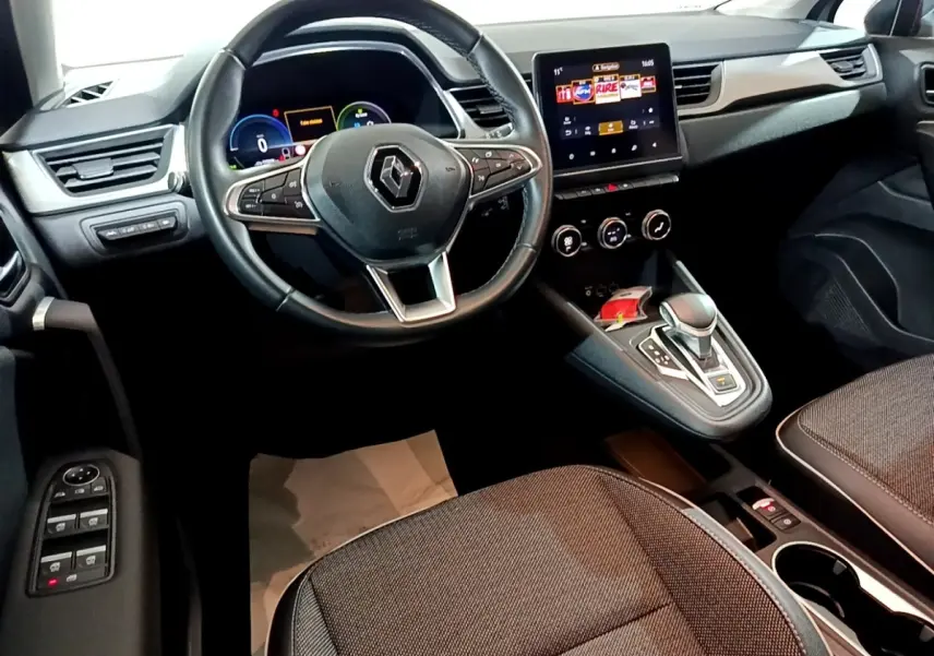 Vue intérieure du tableau de bord et volant cuir du Renault Captur Intens E-Tech hybride rechargeable 2021, avec écran tactile central.