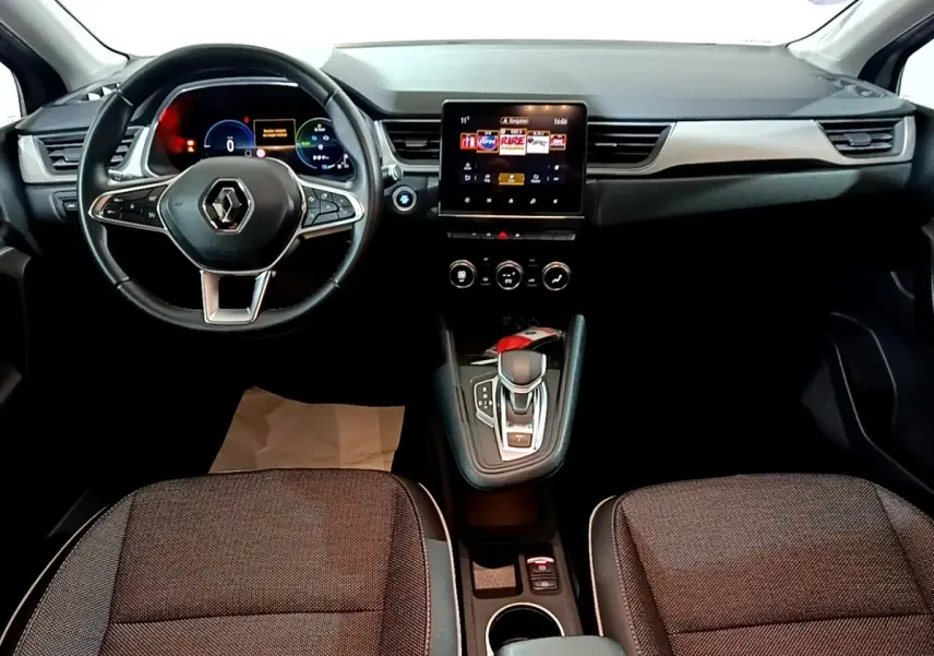 Vue intérieure avant du Renault Captur Intens E-Tech hybride 2021, volant cuir, écran tactile central et levier de boîte auto.
