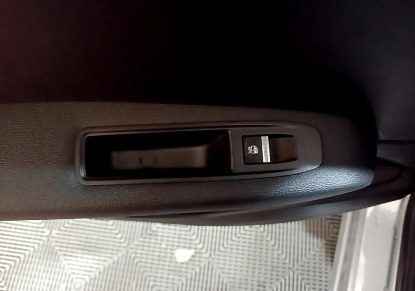 Détail de la commande de lève-vitre électrique côté conducteur sur porte intérieure noire d’un Renault Captur.