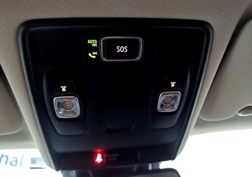 Vue intérieure centrée sur la console de toit noire avec bouton SOS éclairé et plafonnier du Renault Captur gris clair.