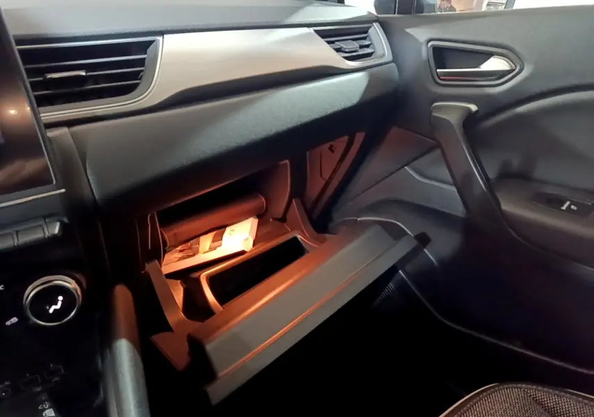 Intérieur Renault Captur Intens E-Tech 2021, vue côté passager sur boîte à gants ouverte et tableau de bord noir.