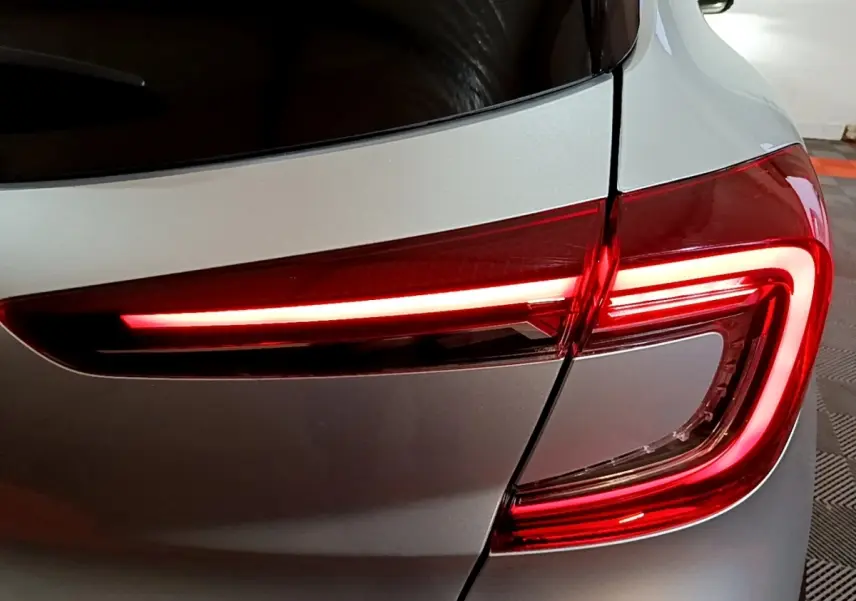 Gros plan sur le feu arrière droit rouge allumé du Renault Captur Intens E-Tech hybride gris clair de 2021.