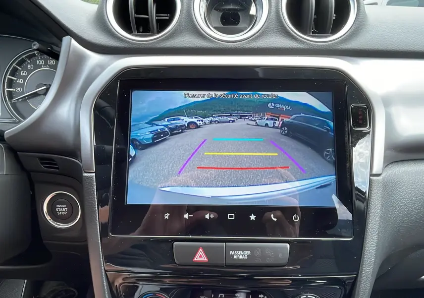 Vue intérieure centrée sur l’écran multimédia affichant la caméra de recul du Suzuki Vitara 1.4 Privilege AllGrip 2025.