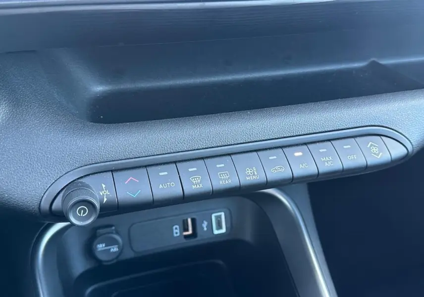 Vue rapprochée de la console centrale noire du Jeep Avenger 2025 montrant les commandes climatisation et ports USB.