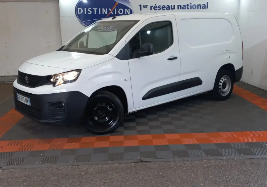 Vue 3/4 avant droit d’un utilitaire Peugeot Partner blanc avec pare-chocs noirs et jantes acier noires.