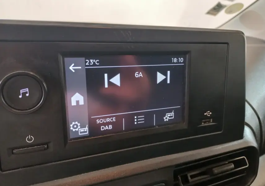 Écran tactile central du tableau de bord du Peugeot Partner 2021 affichant la source radio DAB, avec port USB à droite.
