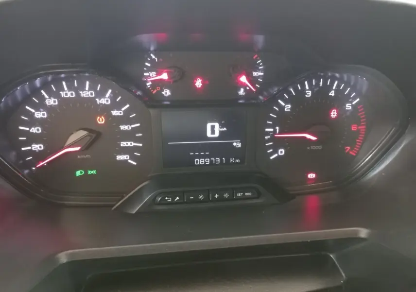 Tableau de bord du Peugeot Partner 2021 avec compteur digital et voyants allumés, vue frontale rapprochée.