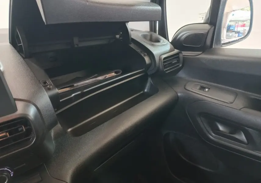 Intérieur côté passager du Peugeot Partner 2021, boîte à gants ouverte et tableau de bord noir.