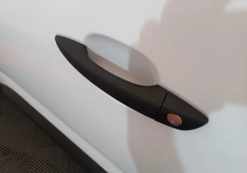 Poignée de porte noire en gros plan sur la porte blanche côté droit du Peugeot Partner BlueHDi 100 Long 2021.