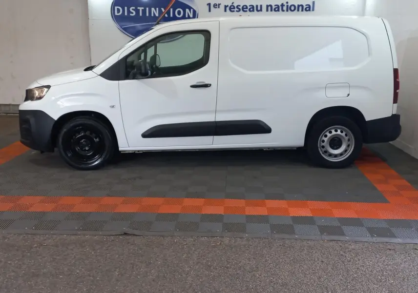 Vue de profil côté gauche d'un utilitaire Peugeot Partner blanc avec protections latérales noires et jantes acier.