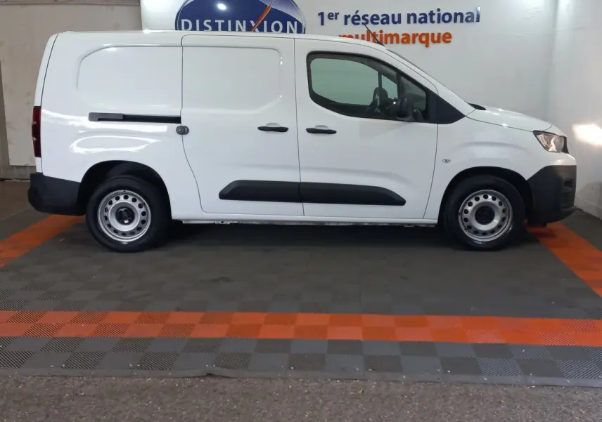 Vue latérale droite d’un utilitaire Peugeot Partner blanc, version BlueHDi 100 Premium, avec portes coulissantes et jantes acier.