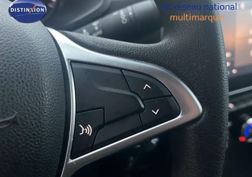 Gros plan sur les commandes du volant noir du Renault Express Van blanc glacier, version TCE 100CH Confort 2023.